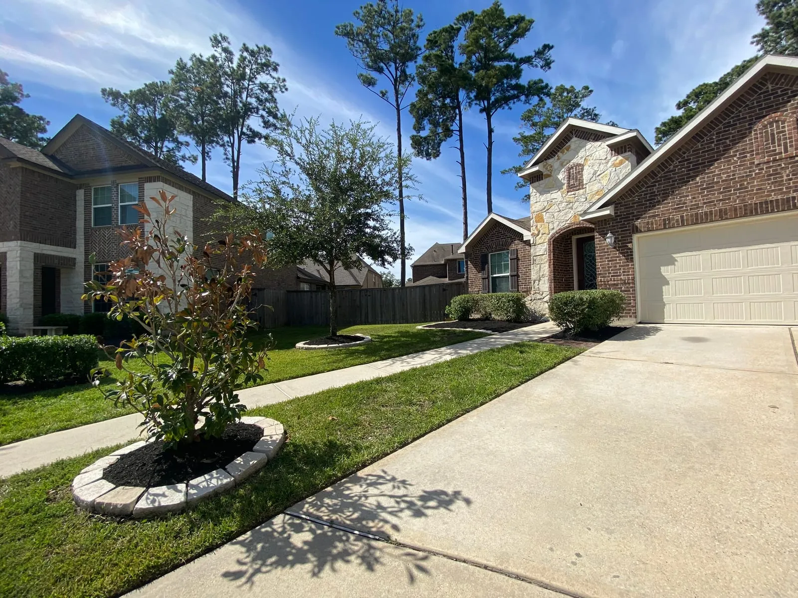 Real Stoneway planting beds and stone-edged tree ring beside a driveway